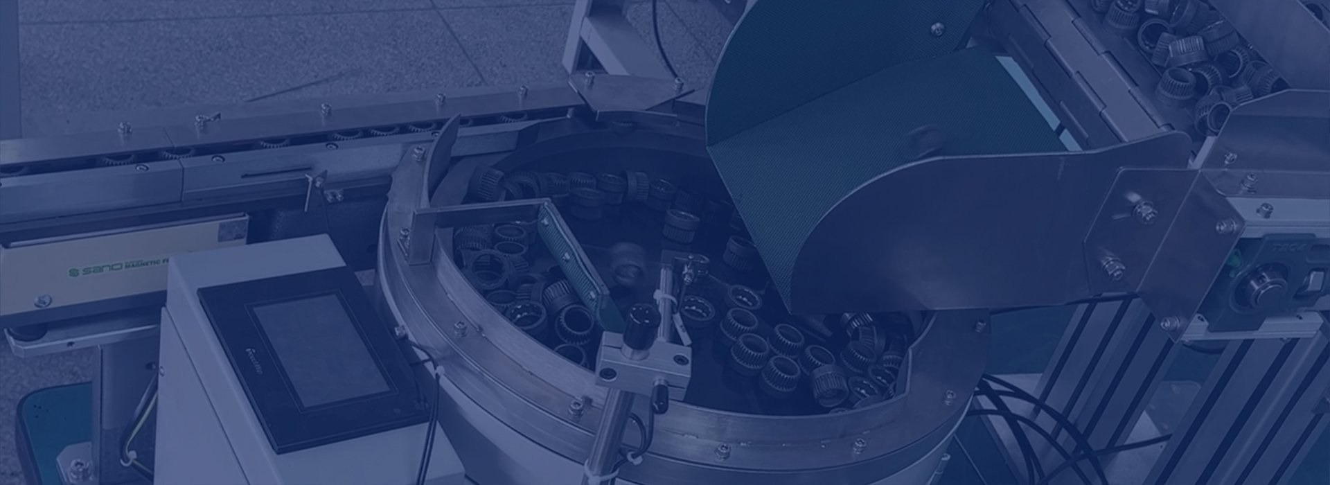 Ring-shaped components in a circular feeder bowl beneath a supply hopper.