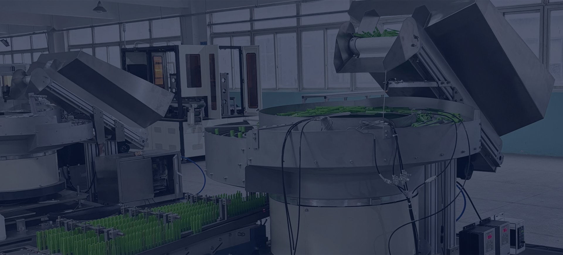 Bowl feeders, hoppers and conveyors with green components.