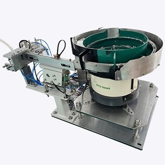 Green-lined bowl feeder with linear outfeed tooling on a metal base.